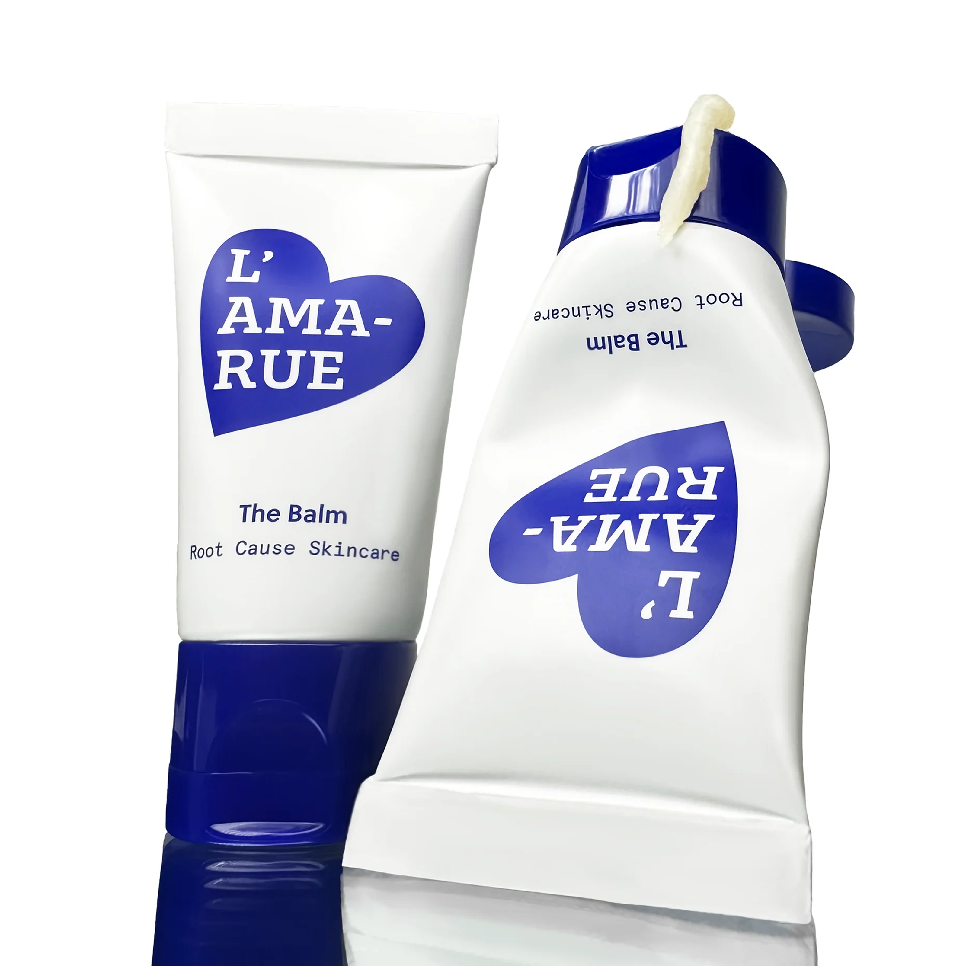 Two tubes of L'AMA-RUE cream with visible cream smeared beside them.
